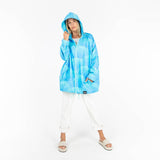 Person wearing a blue wave patterned raincoat on a white background